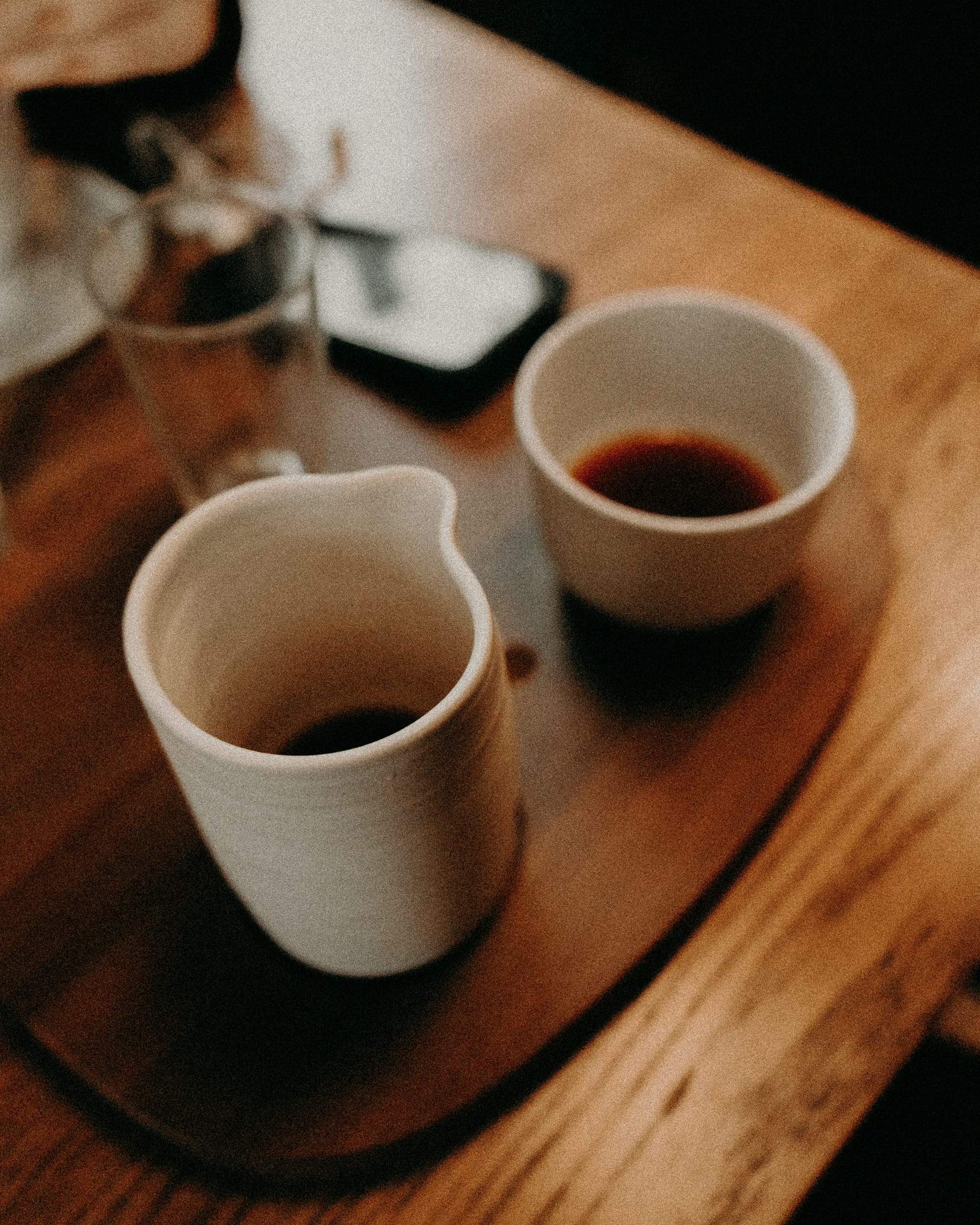 An assortment of used cups and mugs on a table.