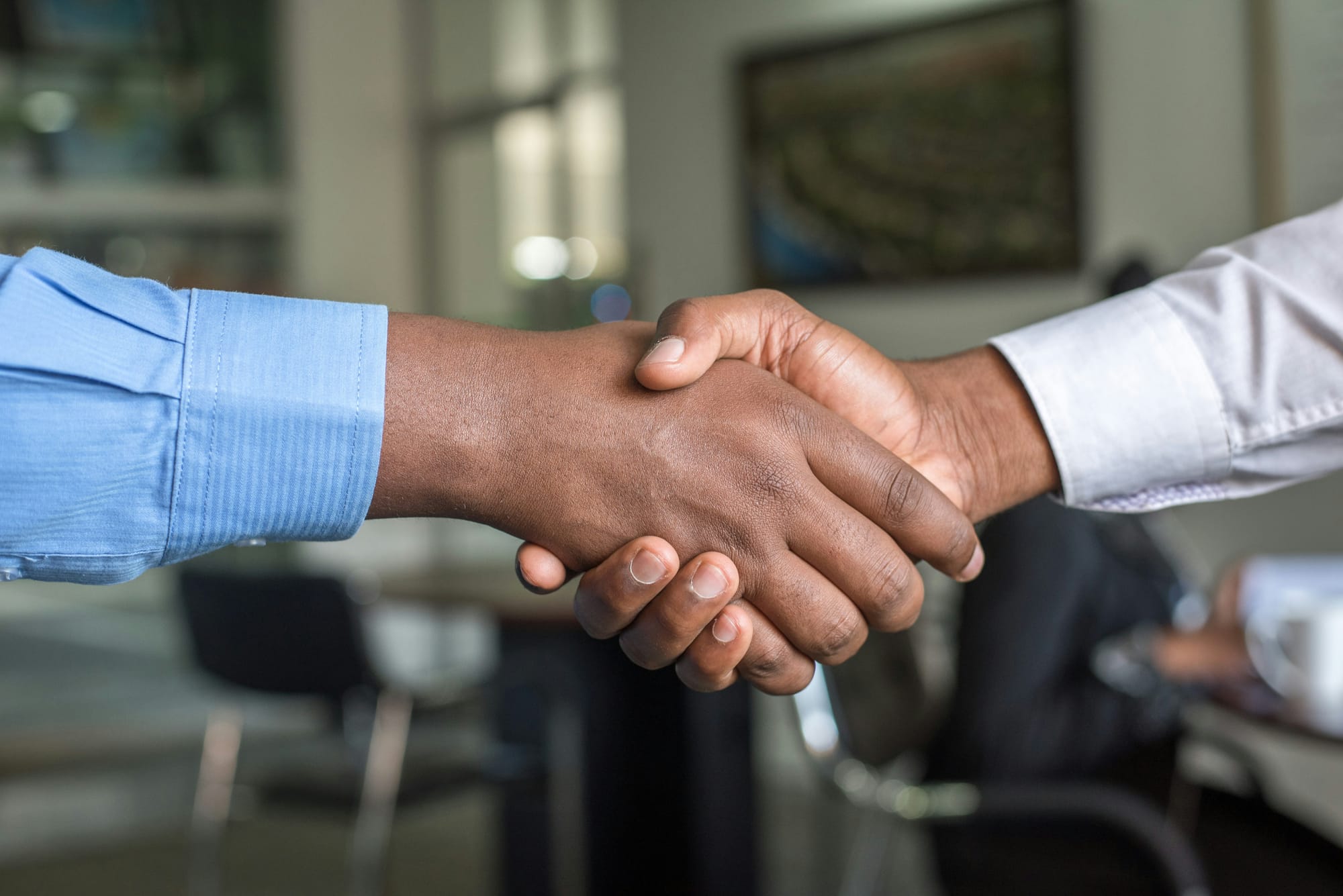 A simple handshake between two people. Only their clasped hands are visible.